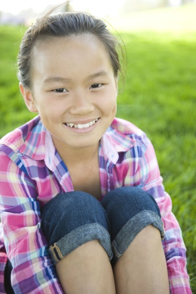 Smiling Chinese girl sitting in grass