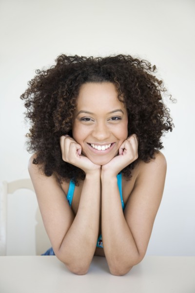 Smiling Hispanic woman with head in hands