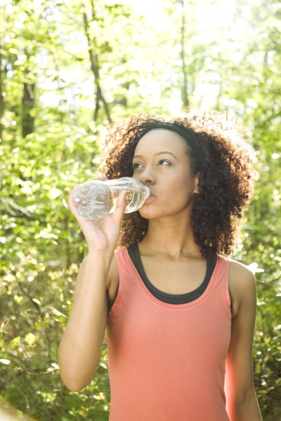 Hispanic woman drinking water after exercise