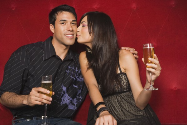 Middle Eastern woman kissing boyfriend's cheek