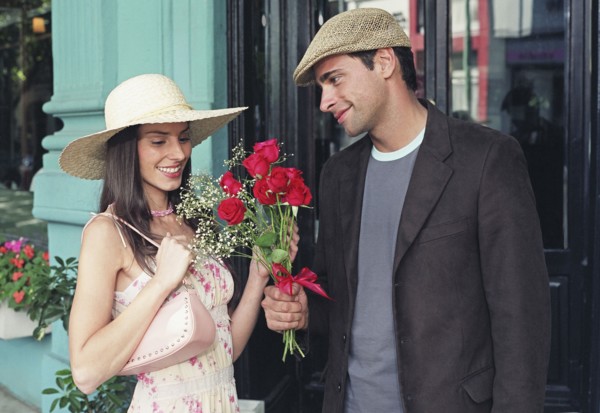 Hispanic man giving flowers to girlfriend