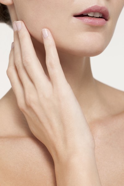 Nude Caucasian woman touching her jaw