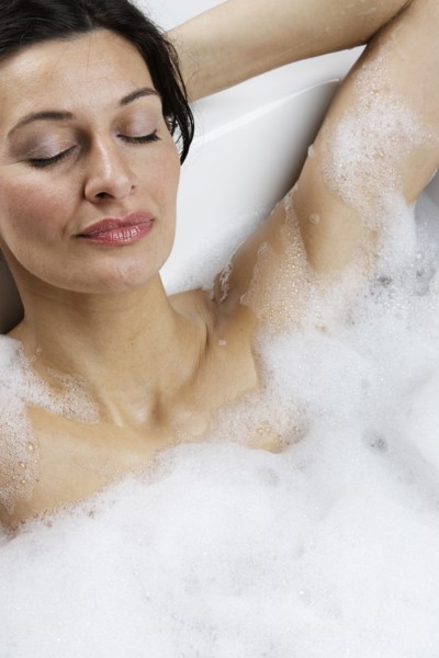 Caucasian woman relaxing in bubble bath