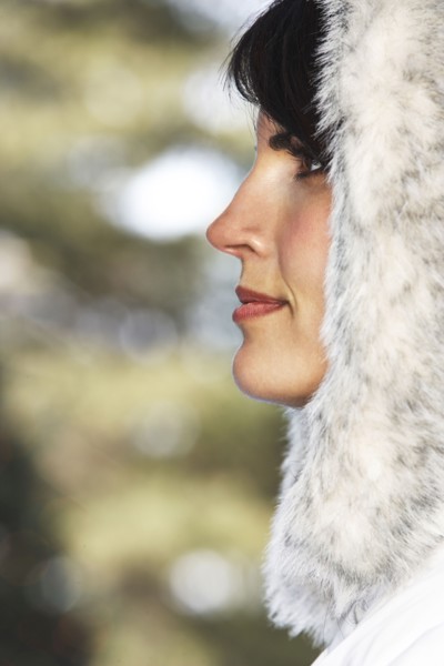 Caucasian woman wearing fur hood in snow