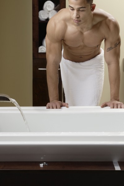 Mixed race man running bath