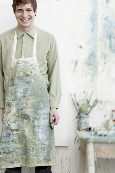 Caucasian artist smiling in studio