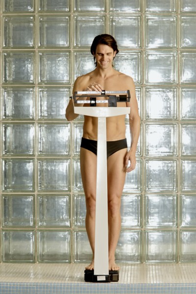Caucasian man weighing himself