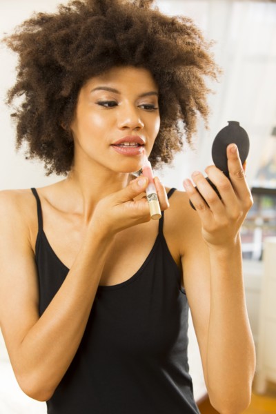 Mixed race woman applying makeup