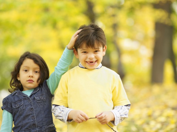 Hispanic brother and sister outdoors in autumn