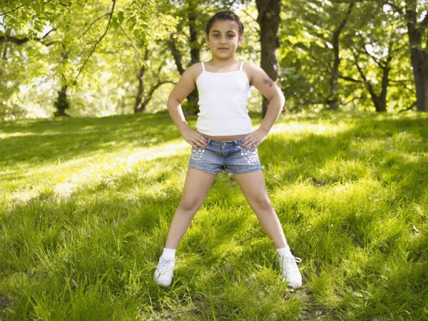 Mixed race girl with hands on hips in grass