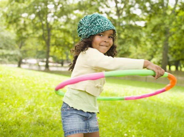 Mixed race girl playing with plastic hoop