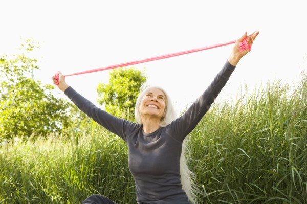 Smiling Caucasian woman stretching with resistance band