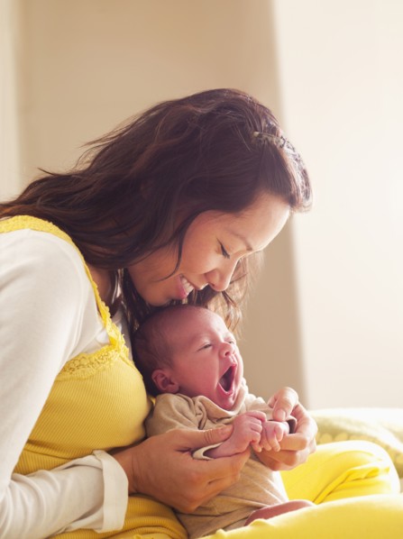 Mother holding newborn baby in her lap
