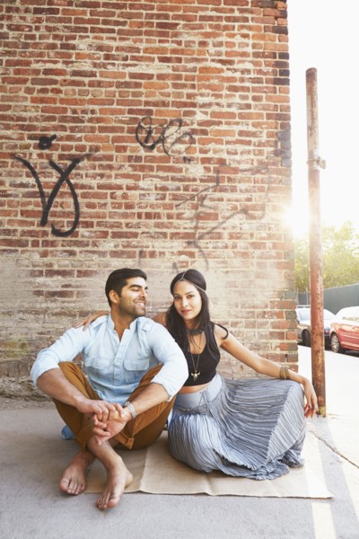 Indian couple sitting on city street