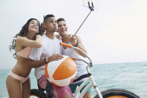 Smiling friends taking selfie on beach