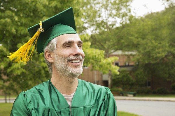 Caucasian college graduate wearing cap and gown