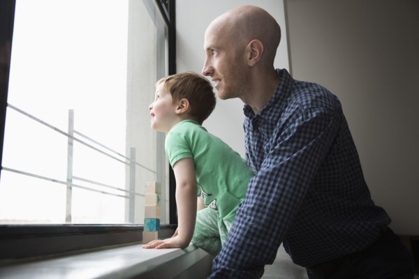 Father and son looking out window