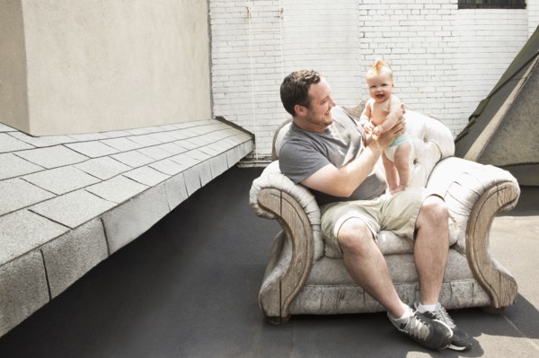Caucasian father and baby daughter sitting in armchair outdoors