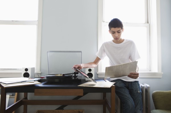 Mixed race teenage boy listening to records