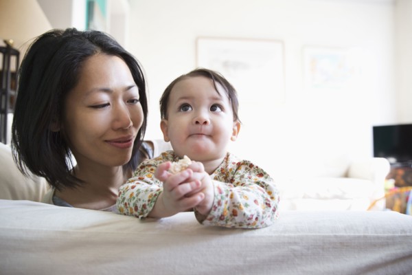 Mother and daughter sitting on sofa