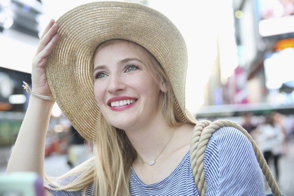 Portrait of smiling Caucasian woman wearing hat in city
