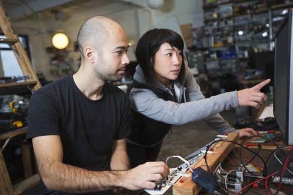 Man and woman working with electronics in workshop