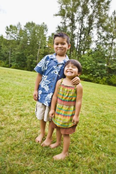 Asian siblings with bare feet outdoors