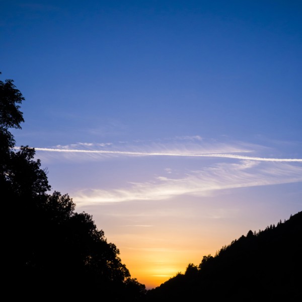 Silhouette of hills under sunrise sky