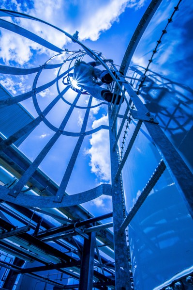 Caucasian man climbing ladder on storage tank