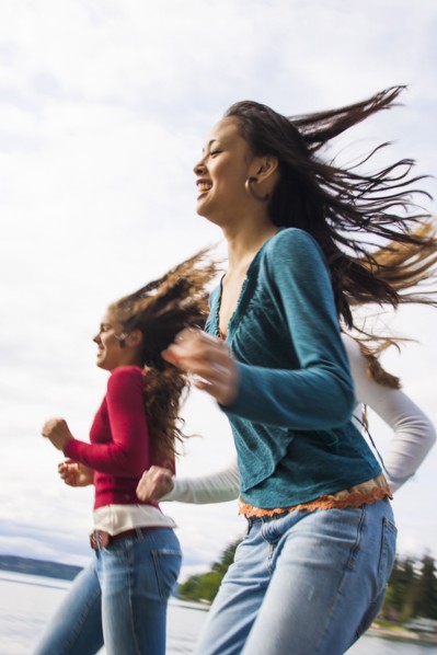 Smiling girls running on beach