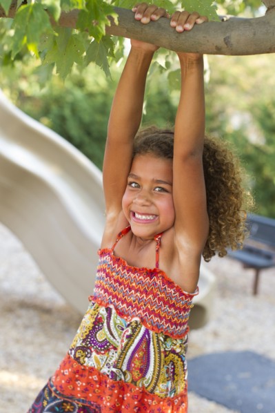 Mixed race girl playing on playground