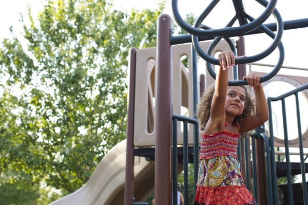 Mixed race girl playing on playground