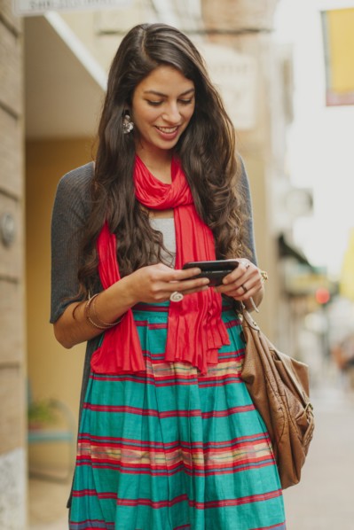 Mixed race woman using cell phone on city street