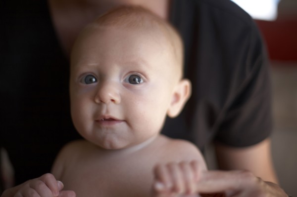 Caucasian mother holding baby's hands