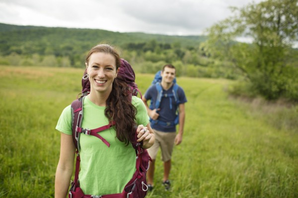 Caucasian couple hiking in rural field