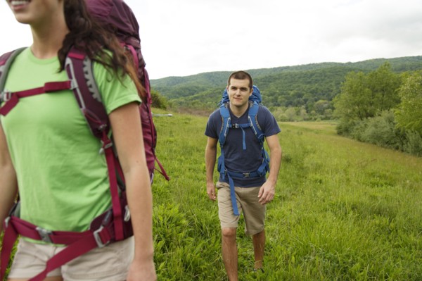 Caucasian couple hiking in rural field