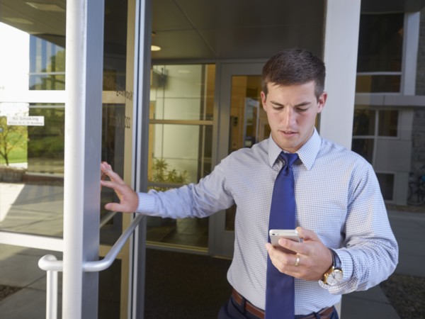 Caucasian businessman using cell phone outside office building