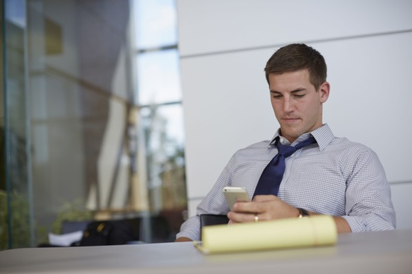 Caucasian businessman using cell phone in office