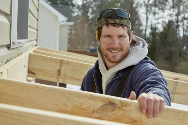 Caucasian carpenter building house extension in winter