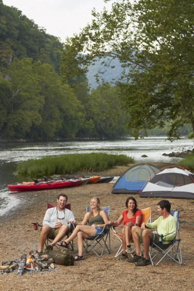 Friends relaxing around campfire at campsite