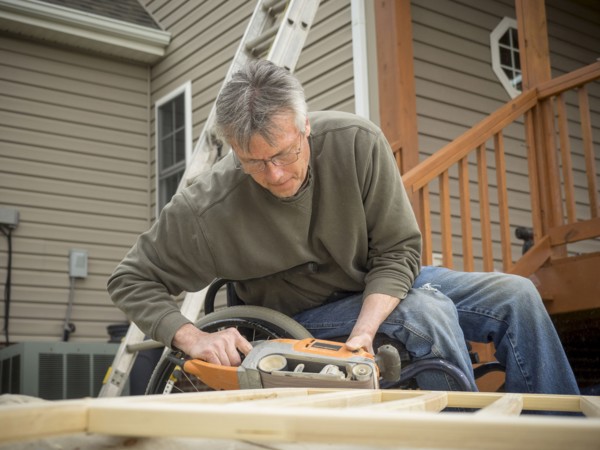 Caucasian paraplegic man wood working in backyard