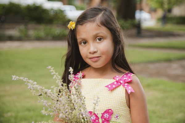 Hispanic girl holding flowers in park