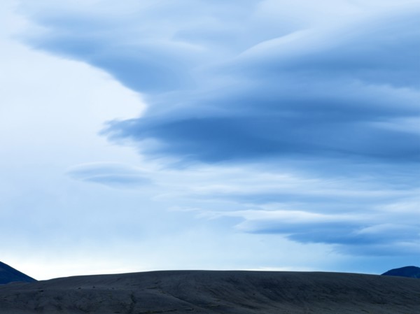 Silhouette of mountain range under cloudy sky