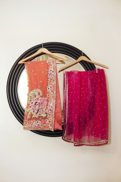 Colorful fabrics hanging by mirror