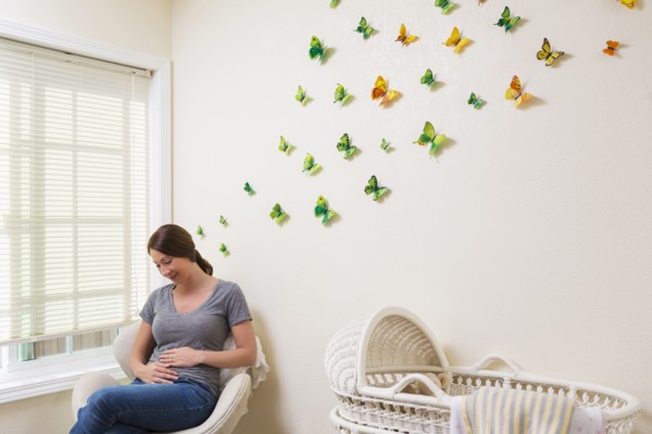 Mixed race pregnant woman sitting in nursery