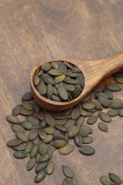 Close up of toasted pumpkin seeds in wooden spoon