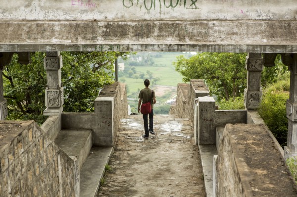 Man walking under stone walkway