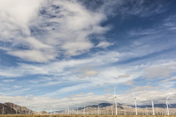 Wind turbines under cloudy sky in remote landscape