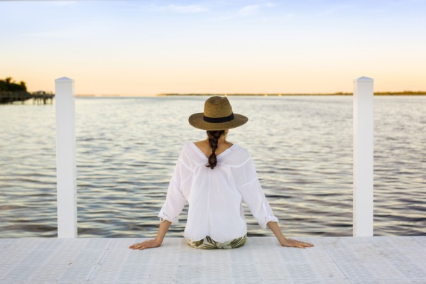 Caucasian woman sitting at edge of pier