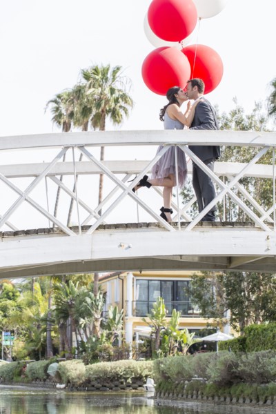 Kissing couple celebrating on bridge with balloons